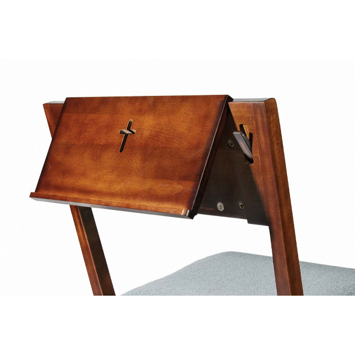 Una scrivania basculante in legno su una sedia o panca da chiesa con una croce scolpita