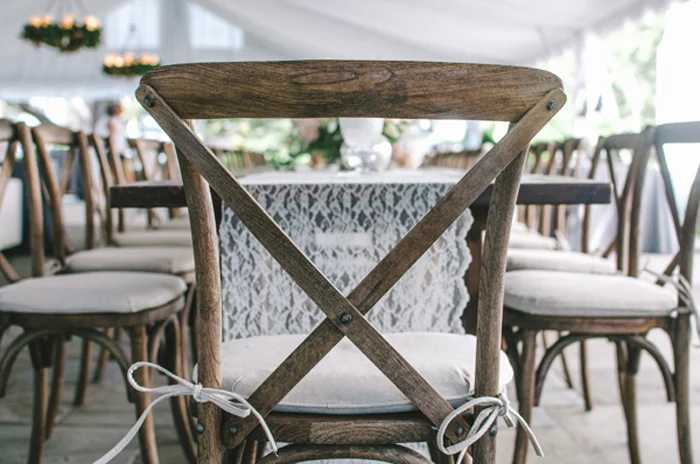 Detalhe de uma cadeira Crossback com uma almofada de assento em um ambiente de assento de casamento