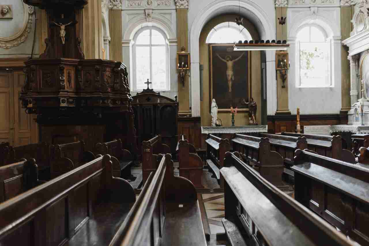 Side view of traditional wooden church pews in two rows.