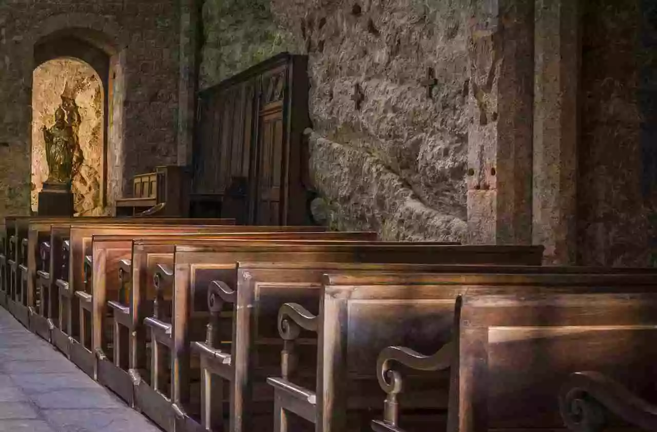 Historyczne ławki kościelne umieszczone w rzędzie w pięknym kamiennym kościele